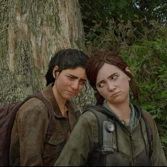 Dina and Ellie leaning against a tree in The Last of Us Part II