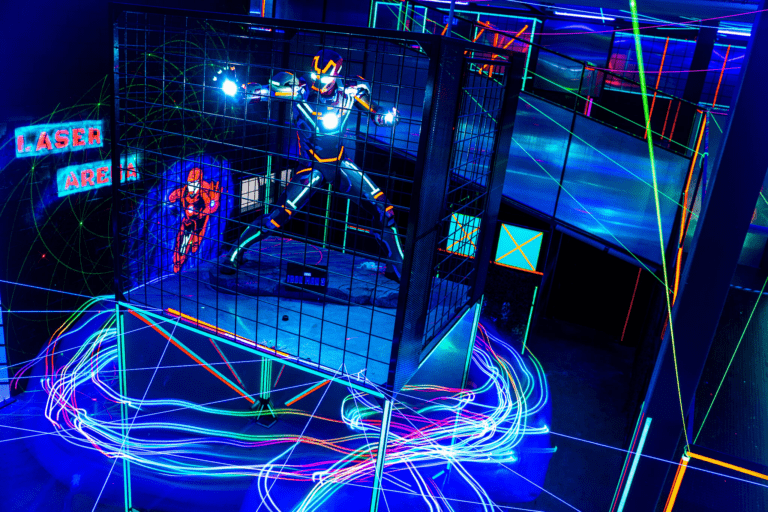 Players competing in an indoor laser game arena with neon lights and obstacles